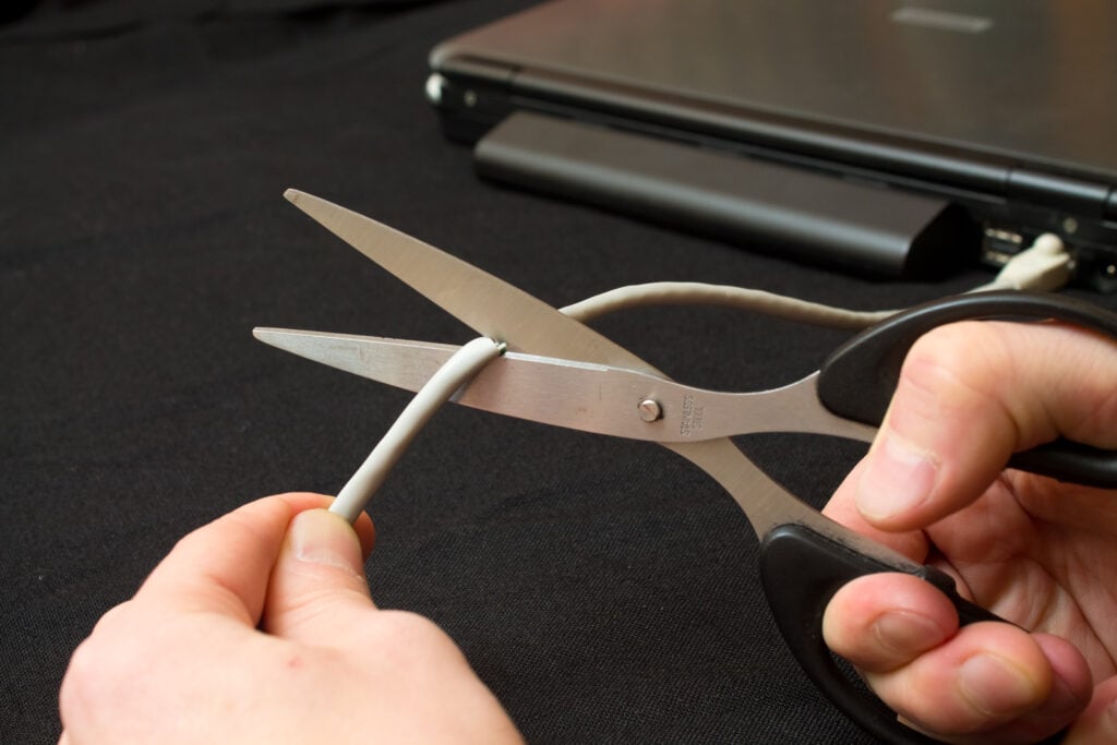 hacked? person holding scissors ready to cut their network cable